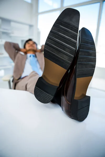 ビジネスマンの彼の机の上に足をリラックス — ストック写真