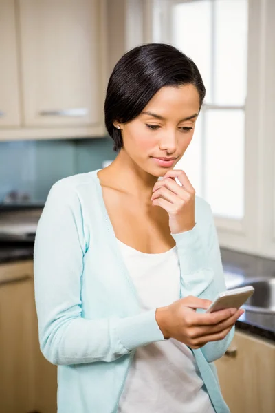 Tankeväckande brunett med smartphone — Stockfoto