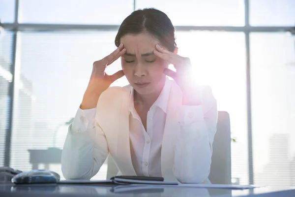 Empresária estressada trabalhando em sua mesa — Fotografia de Stock