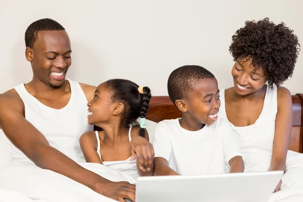 Familia feliz acostada en la cama juntos — Foto de Stock