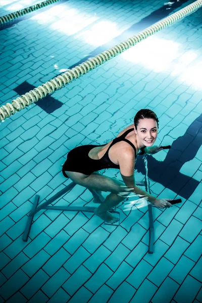 Fit mujer sonriente ciclismo en una bicicleta de natación — Foto de Stock