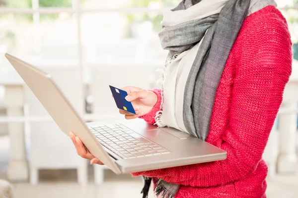 Femme utilisant un ordinateur portable et détenant une carte de crédit — Photo