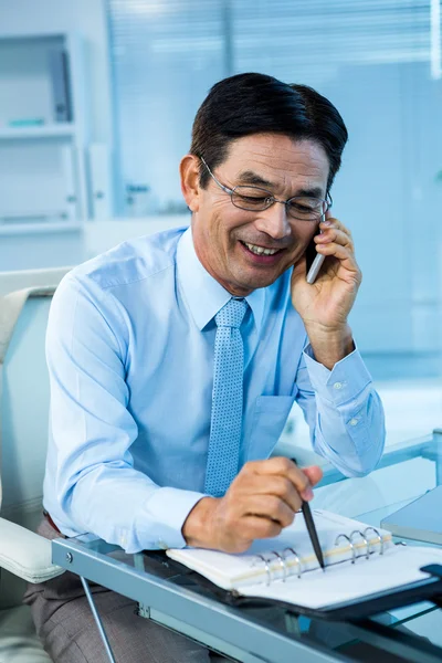 Lächelnder asiatischer Geschäftsmann ruft jemanden an — Stockfoto