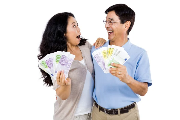 Casal sorridente com dois fãs de dinheiro — Fotografia de Stock