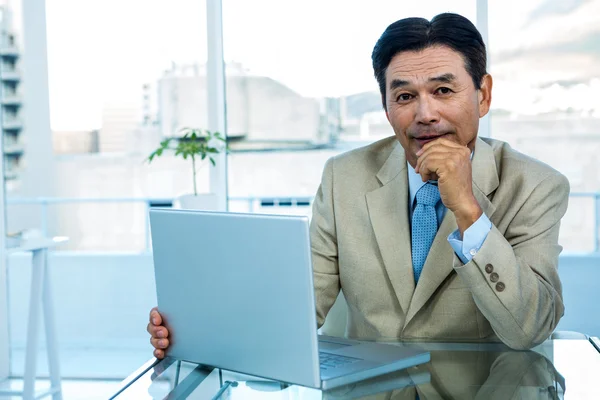 Lächelnder asiatischer Geschäftsmann arbeitet am Laptop — Stockfoto