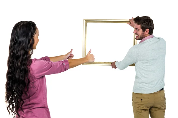 Casal sorridente com moldura de imagem — Fotografia de Stock