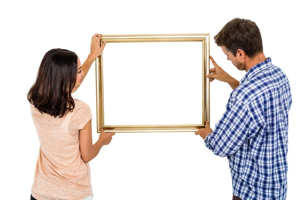 Couple holding picture frame — Stock Photo, Image