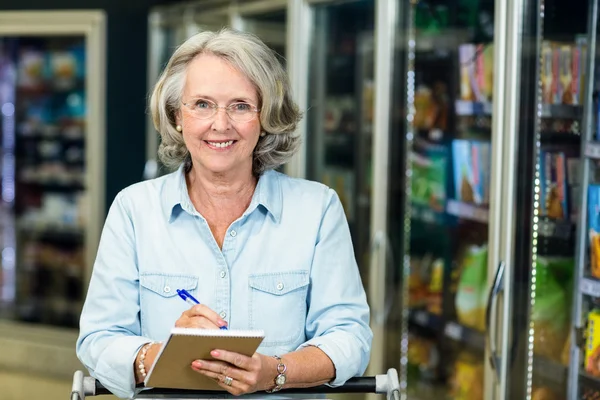 Smiling senior woman holding list — Stock Photo, Image