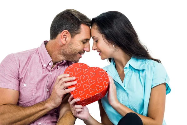 Friedliches Paar mit einer herzförmigen Schachtel — Stockfoto