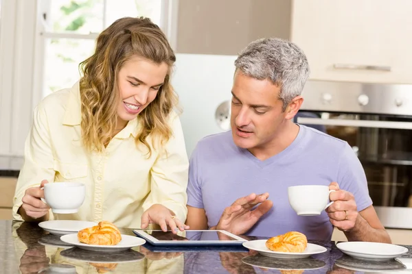 Paar benutzt Tablet und frühstückt — Stockfoto