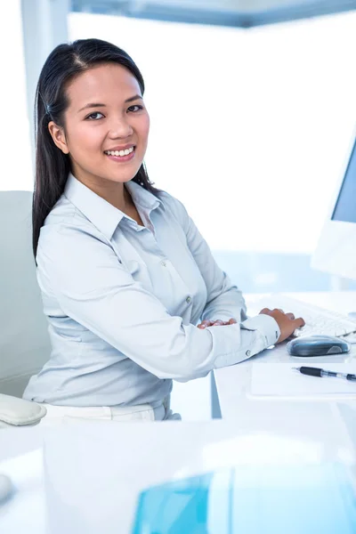 Улыбающаяся деловая женщина, работающая за компьютером — стоковое фото