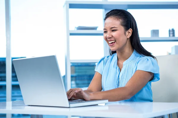 Donna d'affari sorridente utilizzando il computer portatile — Foto Stock