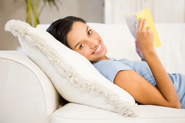 Smiling brunette reading book Stock Picture