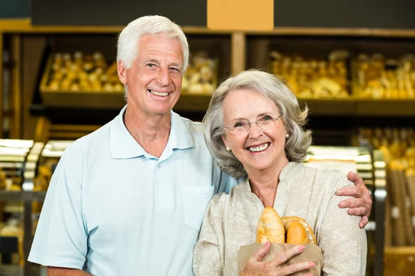 Senior couple holding bakery bag — Stock Photo, Image