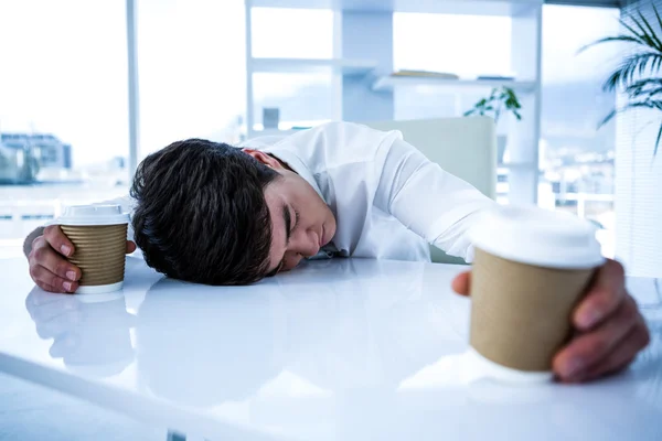 Sovande affärsman holding flammande kaffe — Stockfoto