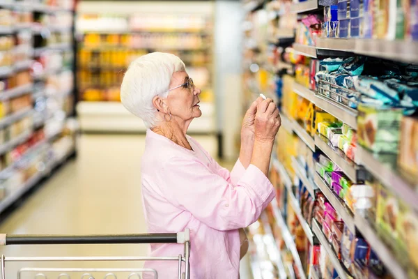 Woman taking picture of product on shelf — Stock Photo, Image