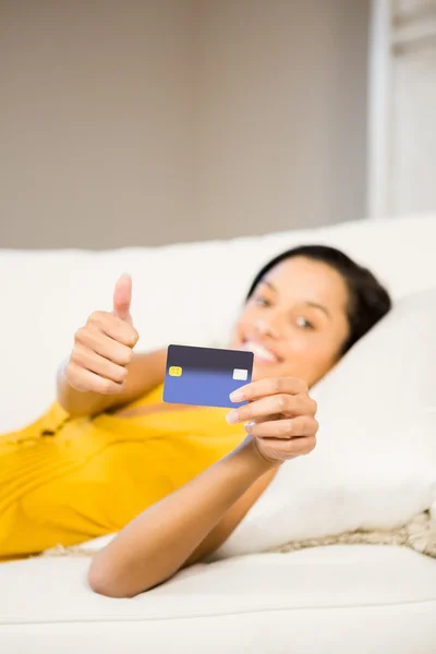 Morena sorridente mostrando cartão de crédito — Fotografia de Stock