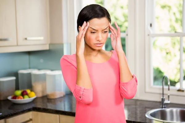 Frowning brunette with hands on face — Stock Photo, Image