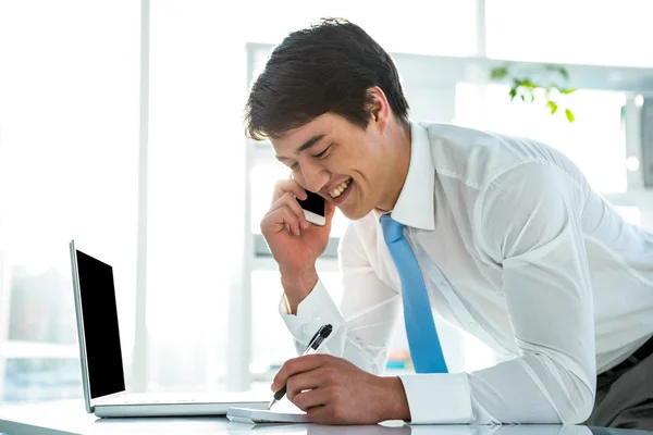 Sorrindo asiático empresário escrevendo notas — Fotografia de Stock