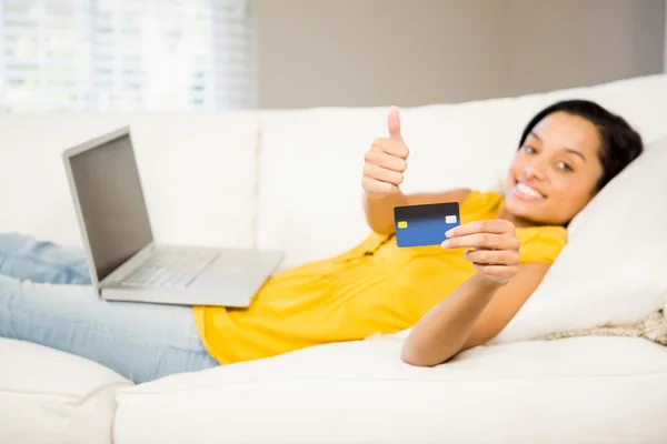 Morena sorridente mostrando cartão de crédito — Fotografia de Stock