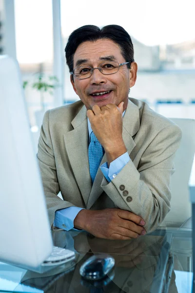 Lachende Aziatische zakenman werken op de computer — Stockfoto