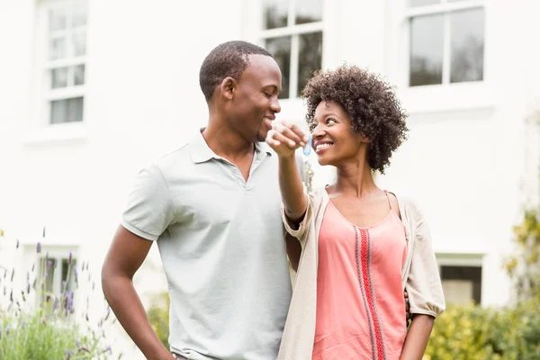 Smiling couple holding keys — Stock Photo, Image