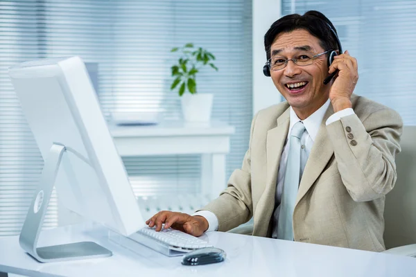 Homem de negócios sorrindo usando fone de ouvido — Fotografia de Stock