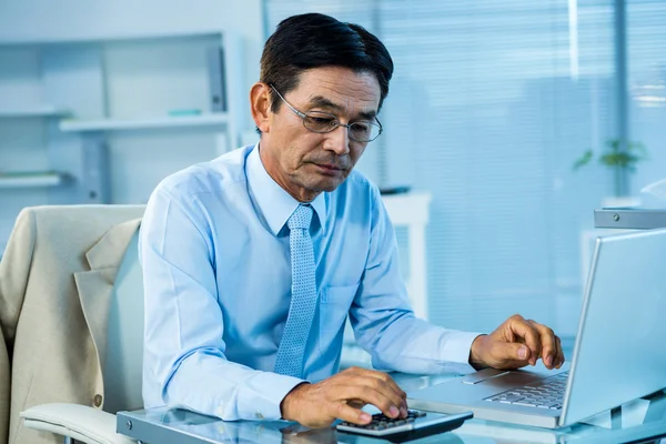 Азиатский бизнесмен с помощью калькулятора — стоковое фото