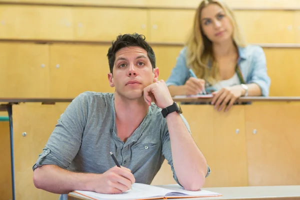 Düşünceli erkek öğrenci sınıf sırasında — Stok fotoğraf