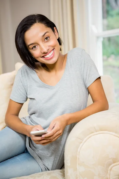 Morena sorridente usando smartphone — Fotografia de Stock