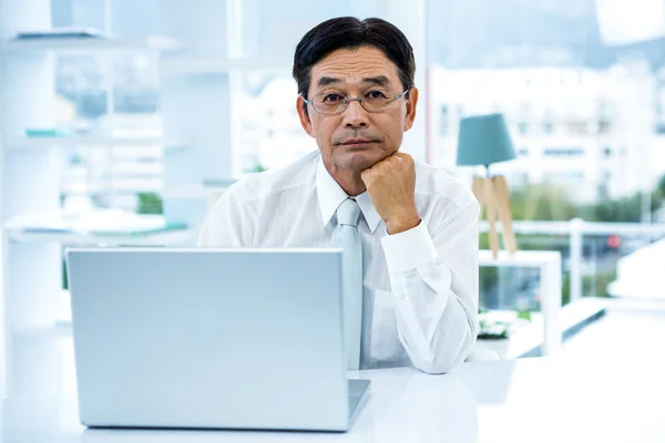 Thoughtful asian businessman looking at the camera — Stock Photo, Image