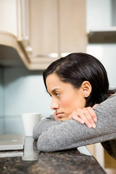 Doordachte brunette kijken naar laptop — Stockfoto