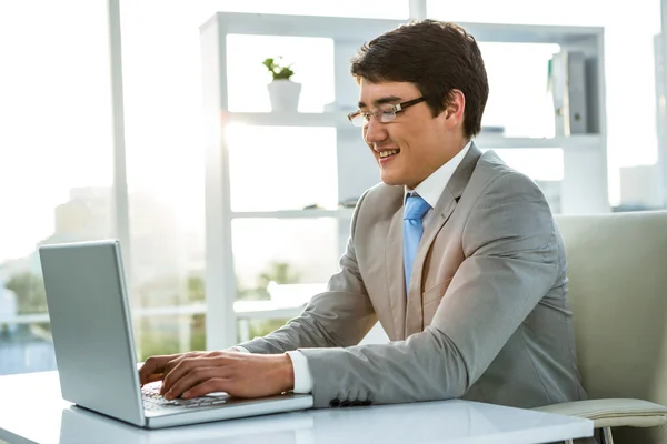 Empresário sorridente usando seu computador — Fotografia de Stock