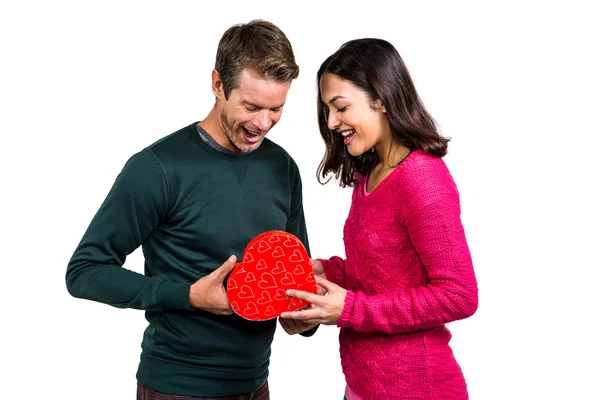 Glückliches junges Paar mit herzförmigem Geschenk — Stockfoto