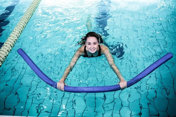 Adatta donna che nuota con un rullo di schiuma — Foto Stock