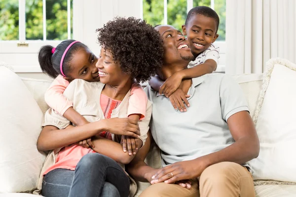 Famille souriante assise sur le canapé — Photo