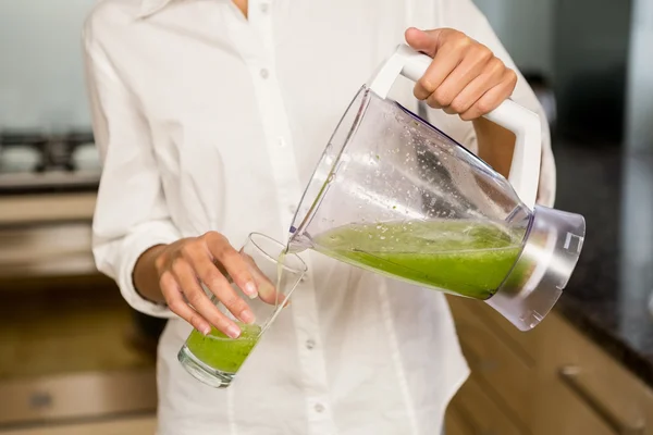 Woman pouring smoothie in glass — Stock Photo, Image