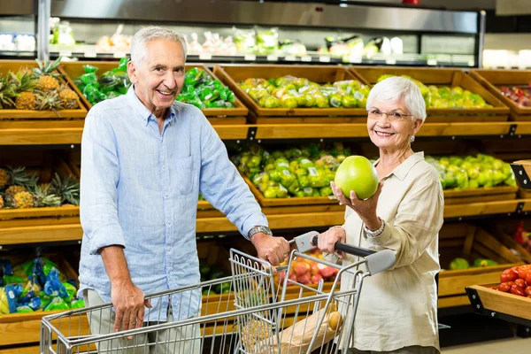 Casal sênior mostrando uma fruta — Fotografia de Stock