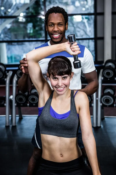 Femme faisant haltères exercice avec entraîneur — Photo