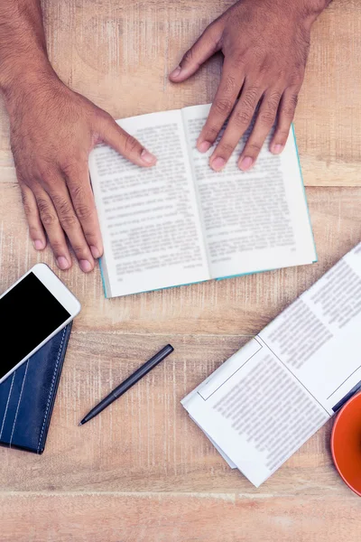 Mann liest Buch auf Tisch — Stockfoto