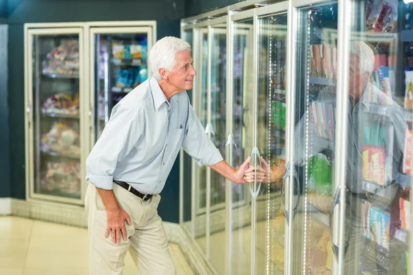 Улыбающийся пожилой человек покупает еду — стоковое фото