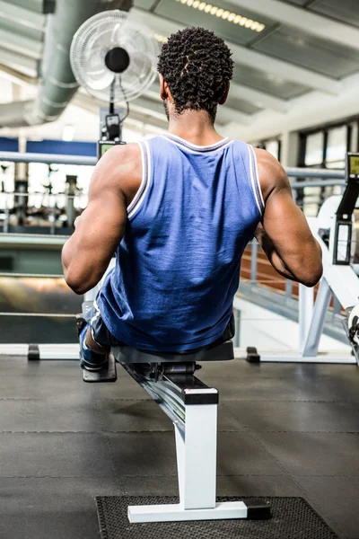 Hombre muscular usando máquina de remo —  Fotos de Stock
