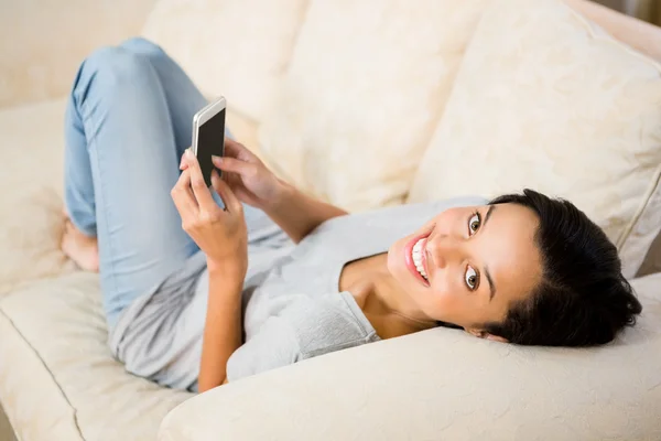 Lachende brunette met smartphone — Stockfoto