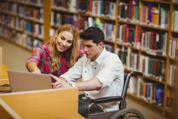 Studente in sedia a rotelle che lavora con compagno di classe — Foto Stock