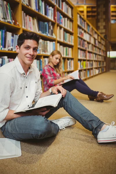Sorrindo estudante do sexo masculino revisão no chão — Fotografia de Stock