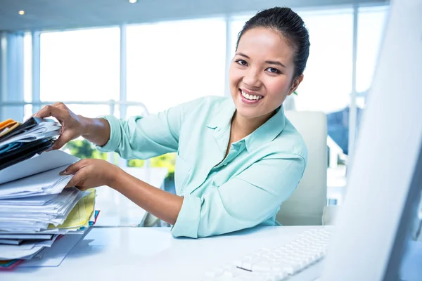 Smiling businesswoman searching files — Stock Photo, Image