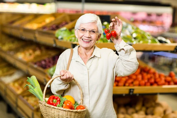 Vrouw met mand en kleine tomaten — Stockfoto