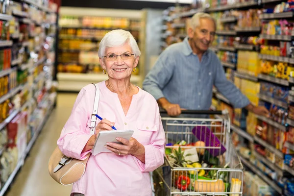 Äldre kvinna med inköpslista — Stockfoto