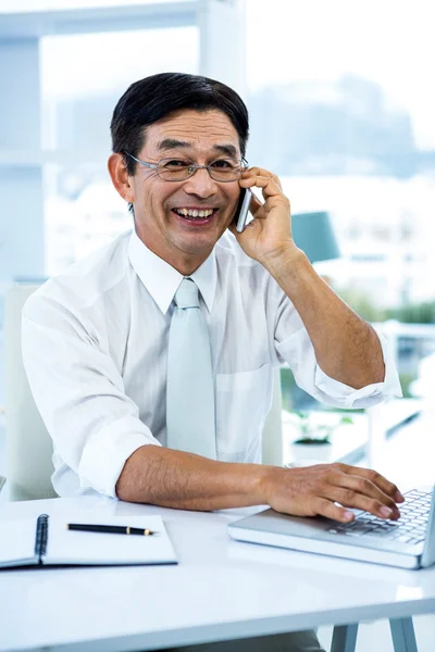 Lächelnder asiatischer Geschäftsmann ruft jemanden an — Stockfoto