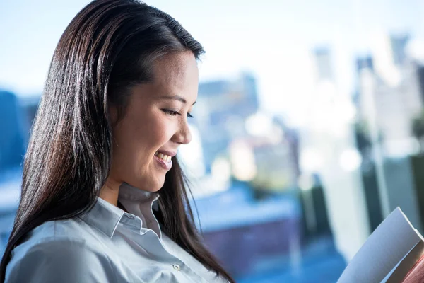 Mujer de negocios sonriente leyendo libro —  Fotos de Stock